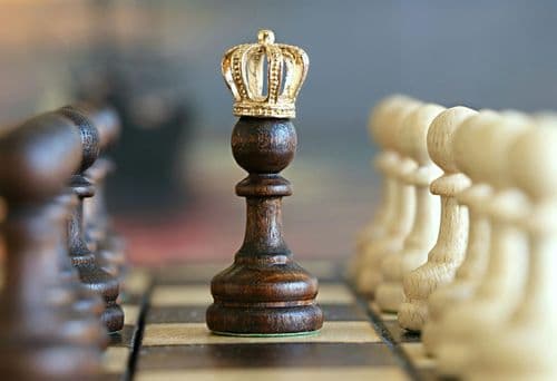A crowned chess pawn standing tall on the board, symbolizing the top-ranked calendar budgeting app of 2026 and representing smart financial strategy and winning money management.